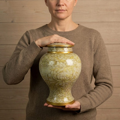holding a decorative floral cremation urn